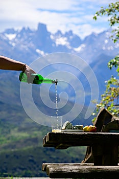 Pouring from high height of natural Asturian cider made fromÂ fermented apples, Asturian cabrales cow blue cheese with view on